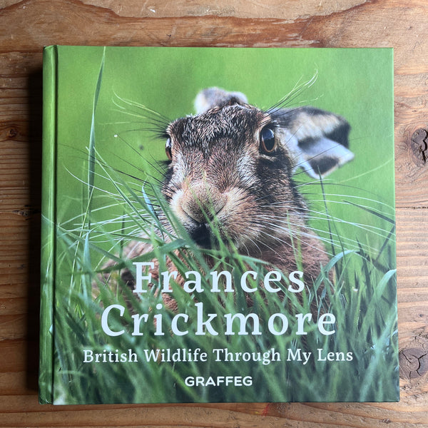 Book cover of 'British Wildlife Through My Lens' by Frances Crickmore on a wooden surface